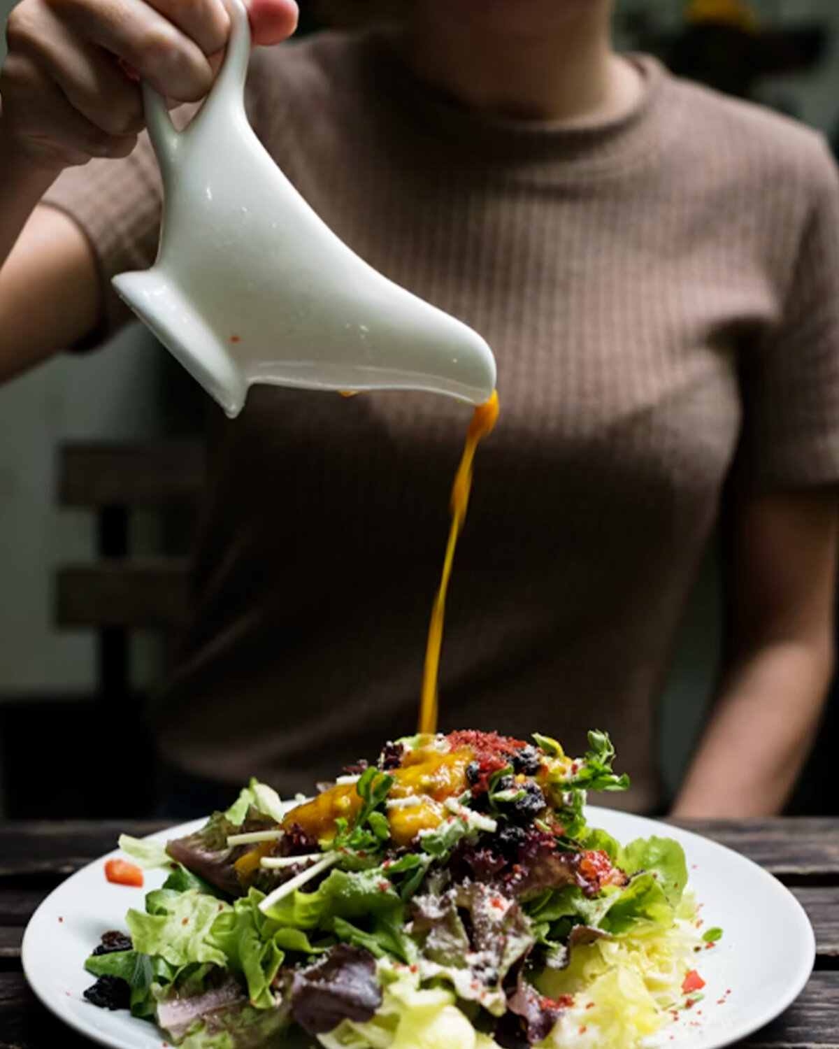 Pouring creamy salad dressing, demonstrating Polysorbate 80 application for preventing oil separation.